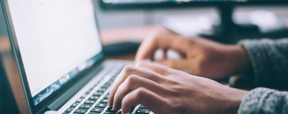 close up of hands using a laptop keyboard