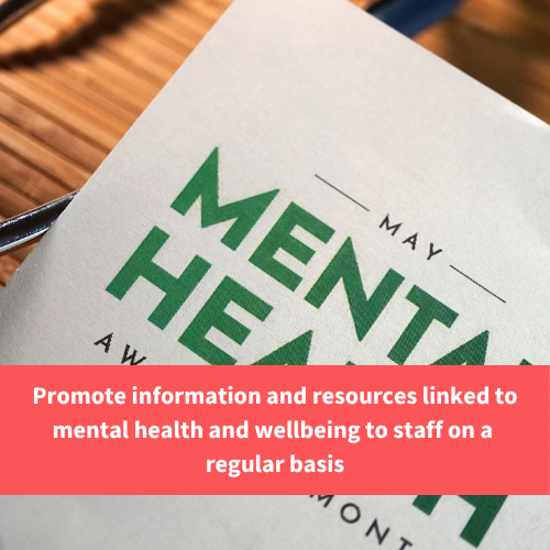 a mental health leaflet on a desk, text reads "Promote information and resources linked to mental health and wellbeing to staff on a regular basis"