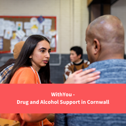 a woman comforting a man with her hand on his shoulder in a group session setting, text reads "withyou - drug and alcohol support in cornwall"